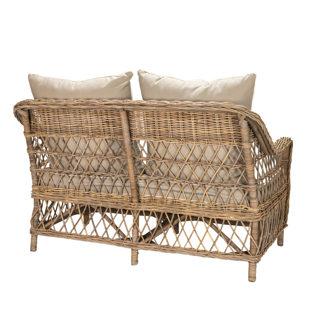 Wicker loveseat with beige cushions on a white background