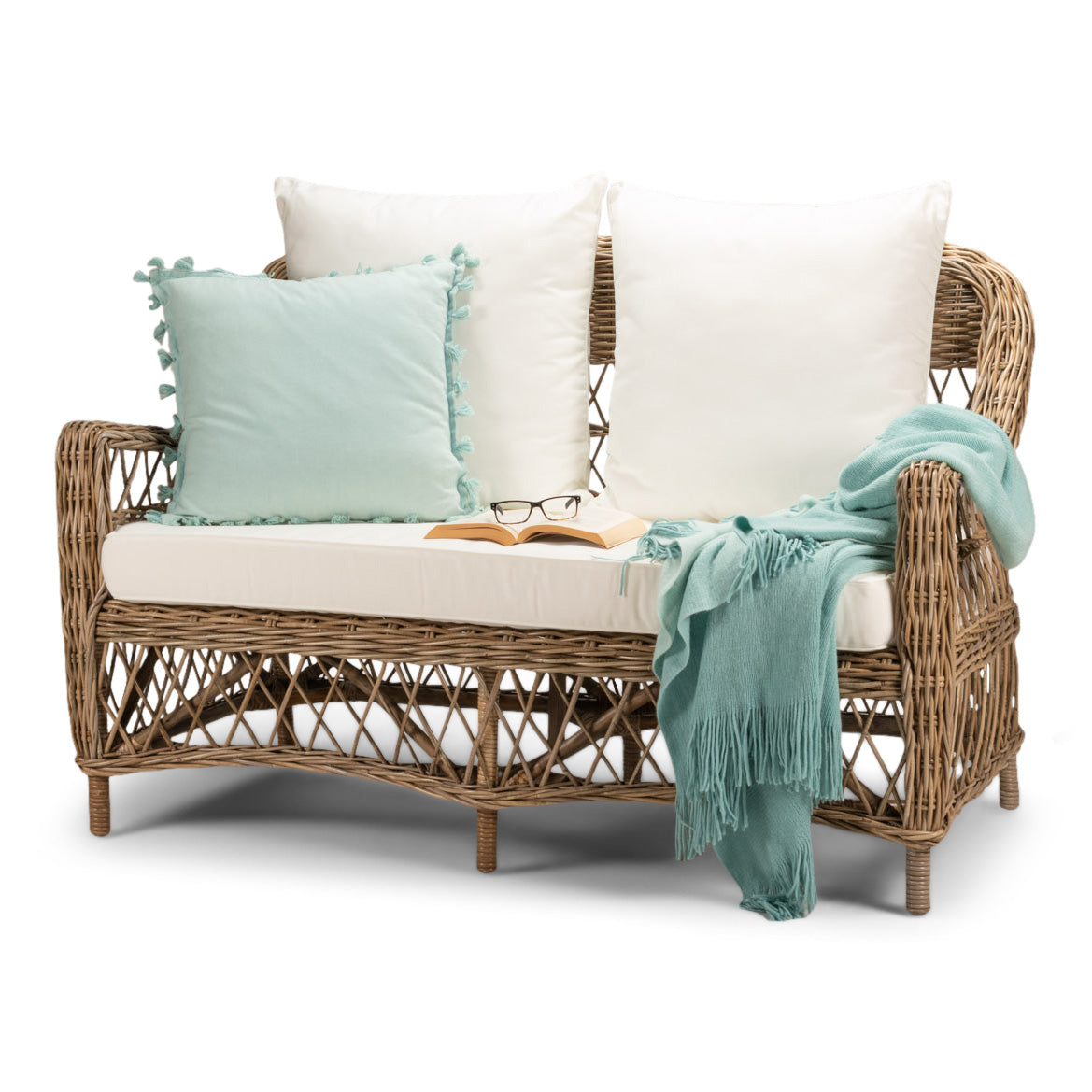 Wicker loveseat with white cushions on a white background